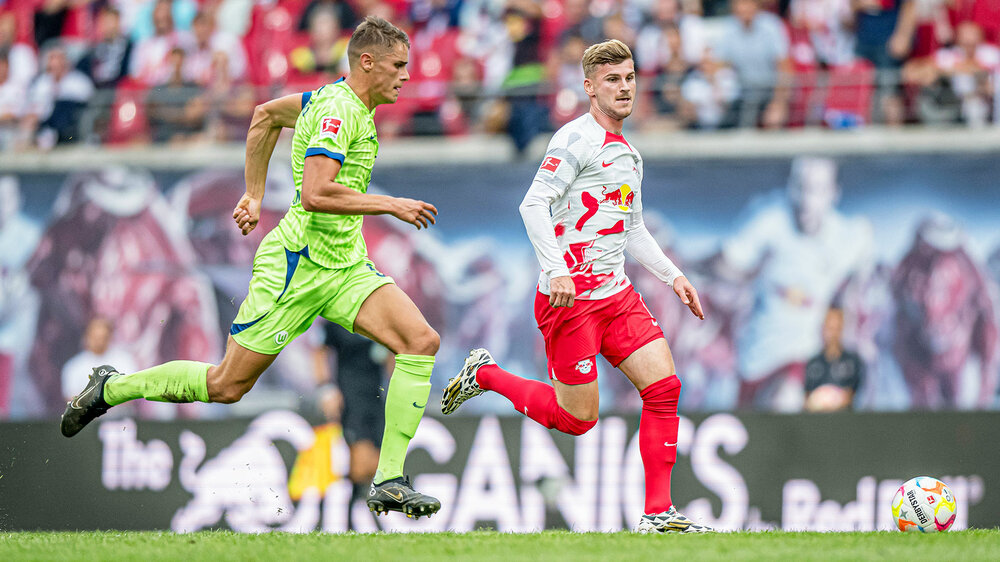 VfL-Wolfsburg-Spieler Micky van de Ven im Laufduell gegen Rb-Leipzig-Spieler Timo Werner.