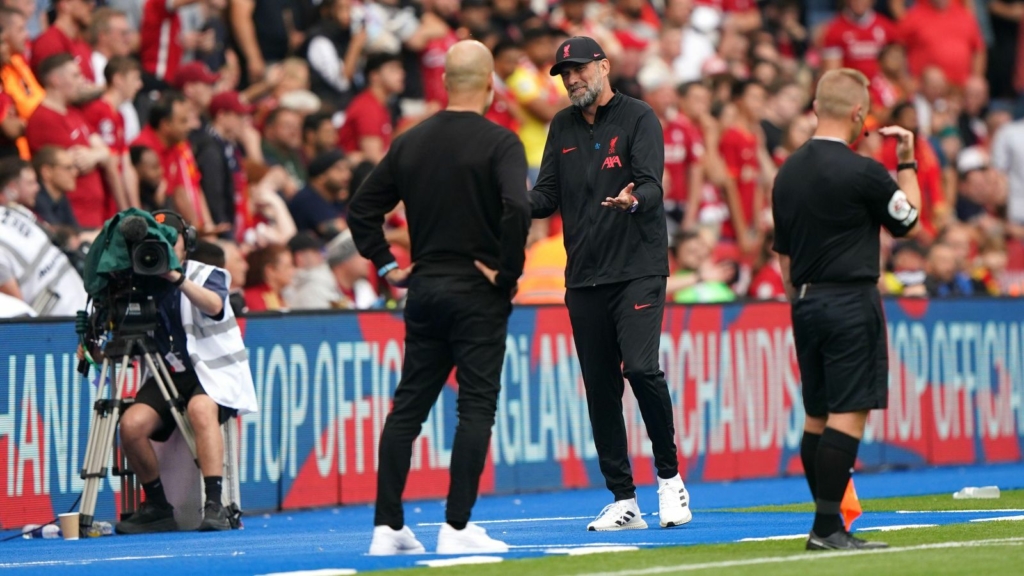 Liverpool boss Jurgen Klopp and Pep Guardiola speak on the touchline