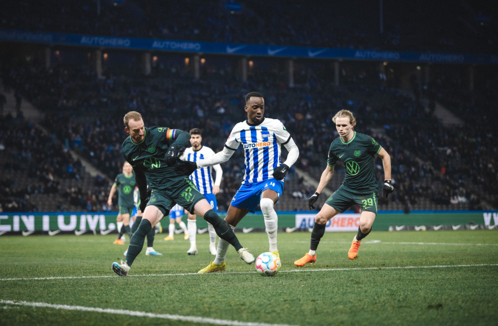 Dodi Lukébakio challenges for the ball with Patrick Wimmer and Maximilian Arnold