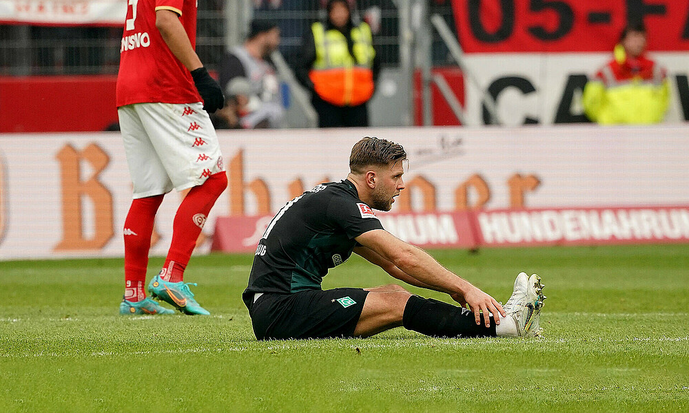 Niclas Füllkrug sits on the floor.