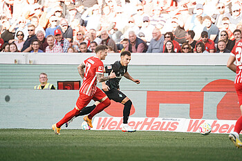 Lee Buchanan chasing down a Freiburg player.