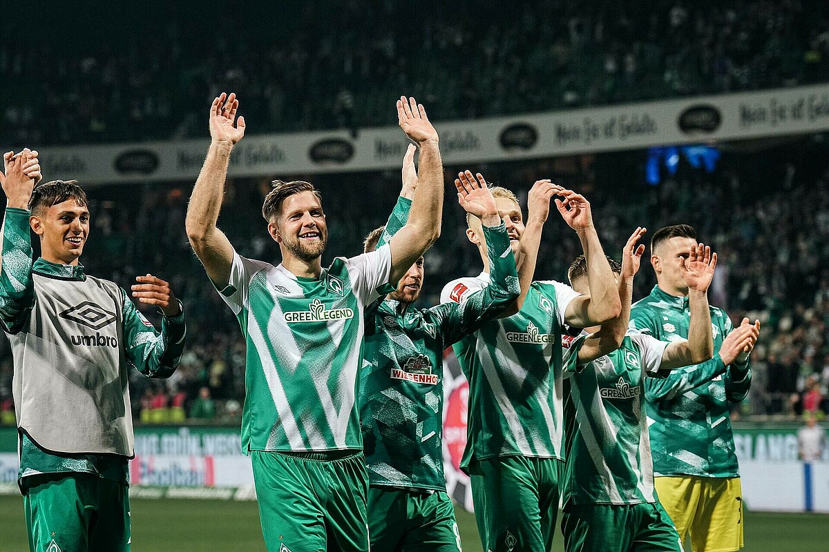 Niclas Füllkrug celebrating with his arms raised.