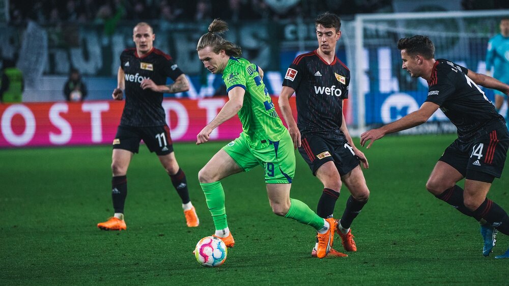 VfL-Wolfsburg-Spieler Patrick Wimmer setzt sich gegen einen Gegenspieler durch und schießt aufs gegenerische Tor.