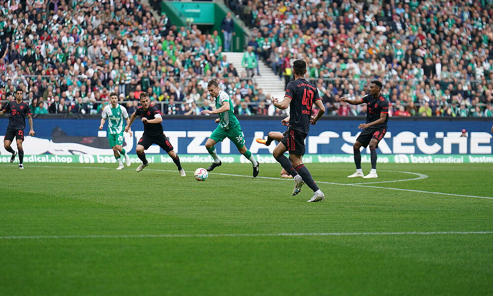 Christian Groß running with the ball at his feet in the penalty area.