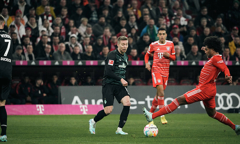 Mitchell Weiser and Serge Gnabry challenge for the ball