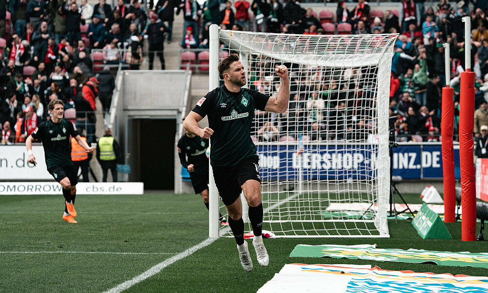 Niclas Füllkrug celebrating and showing his biceps.