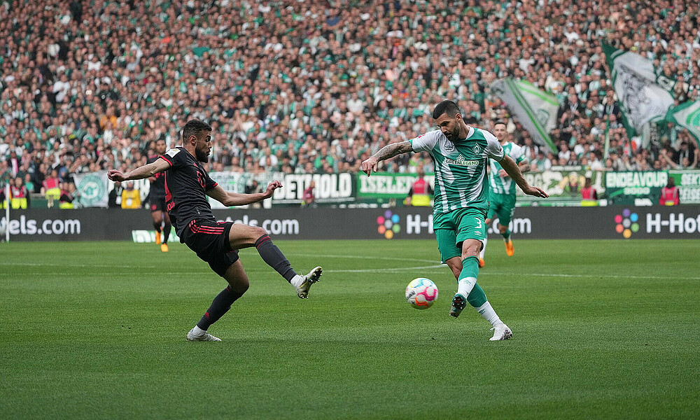 Anthony Jung crossing the ball with Mazraoui next to him.