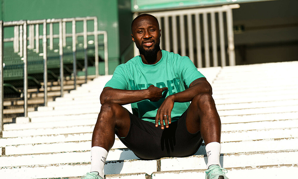 Naby Keïta sitting in the stands at the wohninvest WESERSTADION.