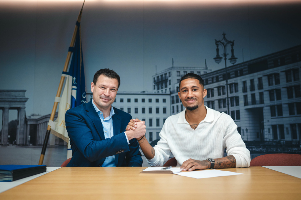 Benjamin Weber and Jeremy Dudziak shaking hands at the contract signing.