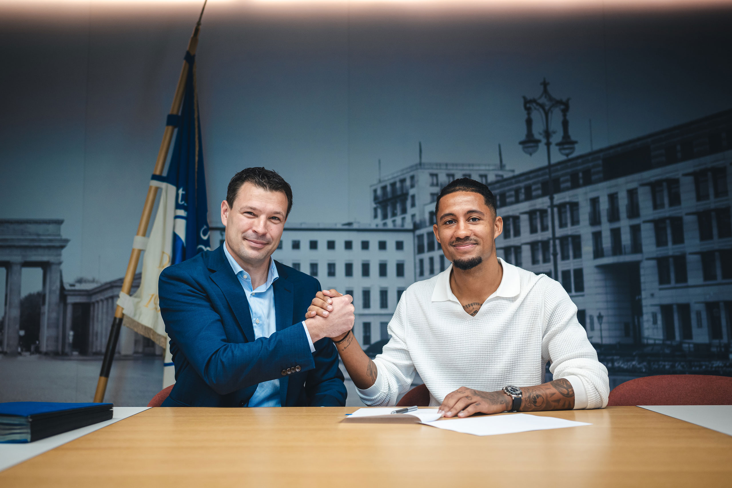 Benjamin Weber and Jeremy Dudziak shaking hands at the contract signing.