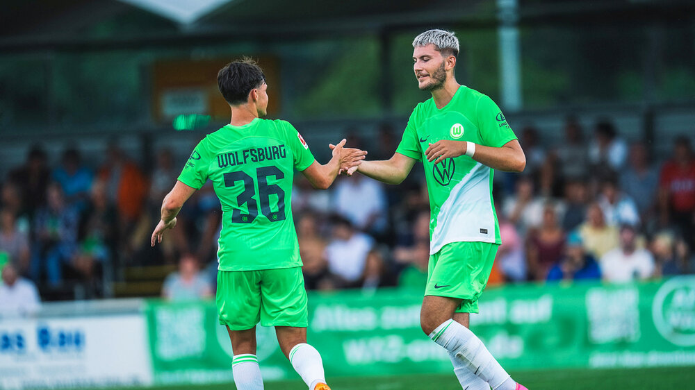 Ambros und Wind vom VfL Wolfsburg klatschen sich ab.