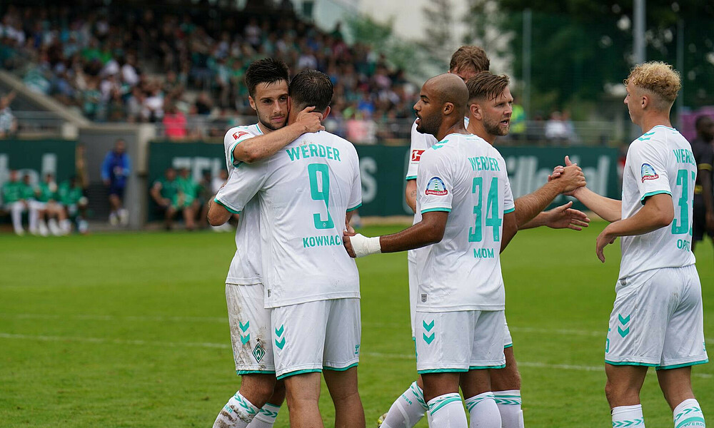 Werder players celebrating a goal together.