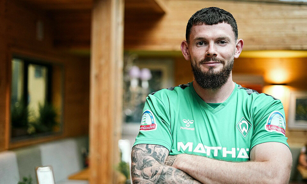 Oliver Burke in the hotel with crossed arms.