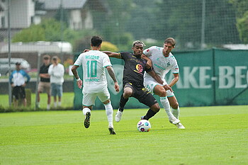 Niklas Stark duelling for the ball with a Toulouse player, while Leonardo Bittencourt runs towards them.