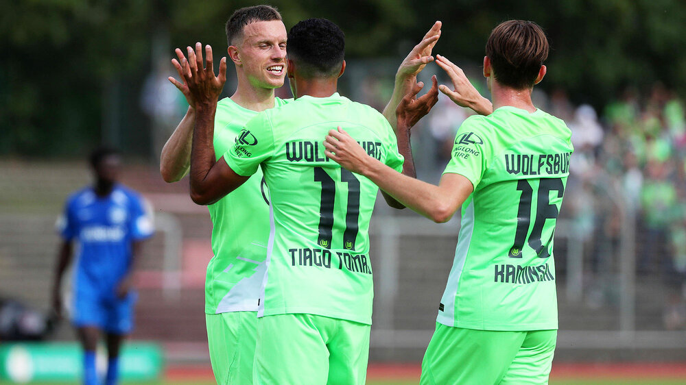 Yannik Gerhard, Tiago Tomas und Jakub Kaminski vom VfL Wolfsburg klatschen sich ab.