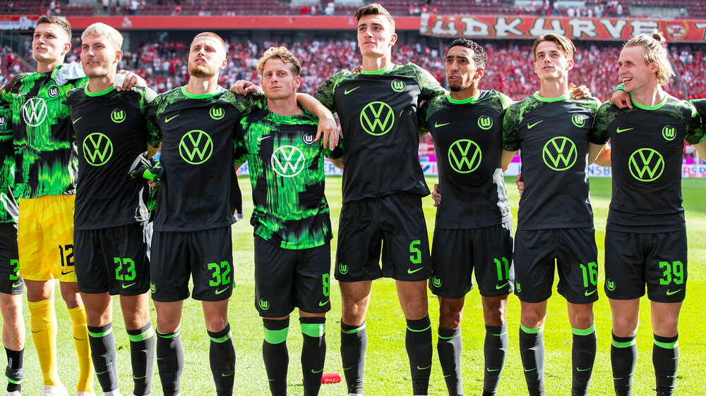 Die Mannschaft vom VfL Wolfsburg jubelt zusammen mit den Fans.