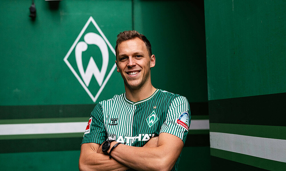 Senne Lynen crossing his arms in a Werder shirt.