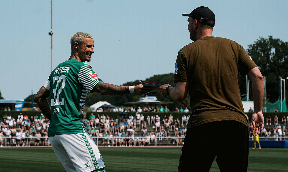 Marco Friedl hands Ole Werner a pennant