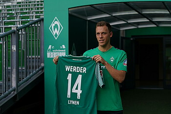 Senne Lynen holding up the Werder number 14 shirt.