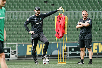 Ole Werner leans on a figure at training.