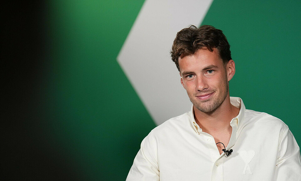 [Translate to Englisch:] Olivier Deman in front of a green wall