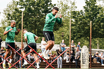 Milos Veljkovic jumps over hurdles in training.