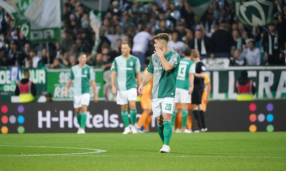 A dejected Romano Schmid walks across the pitch