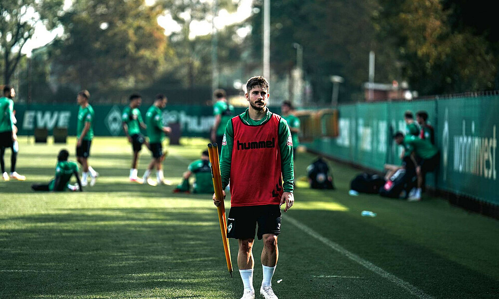 Romano Schmid holding a pole at training.