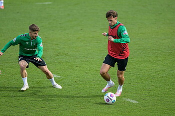 Schmid and Deman battle for the ball in training.