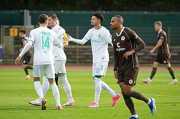 Justin Njinmah high-fiving his teammates.