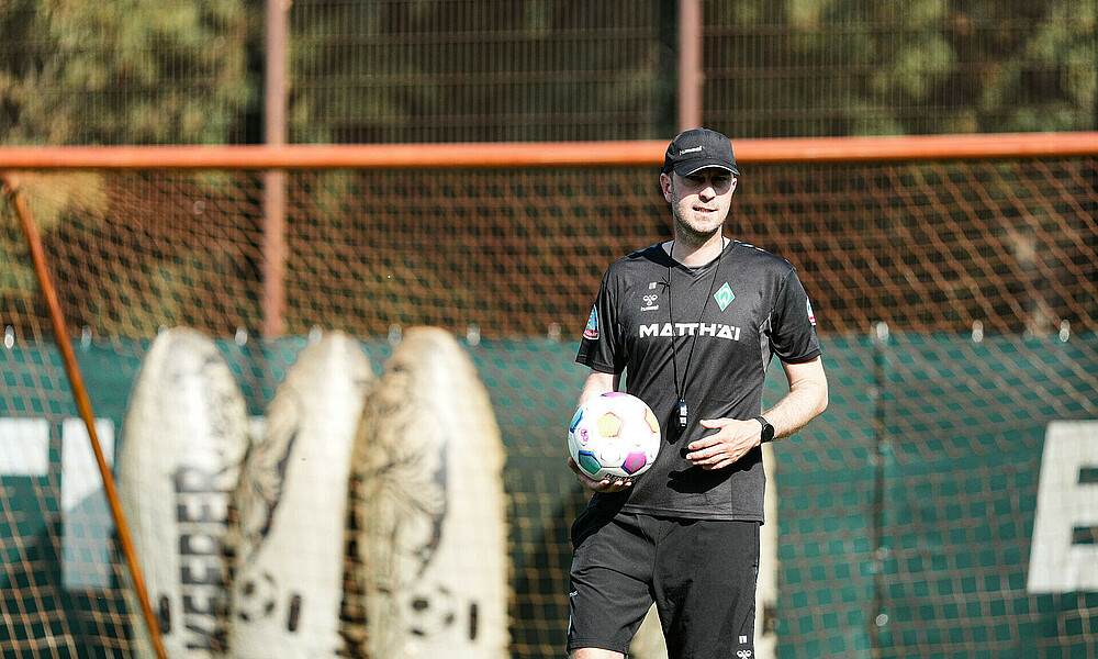 Ole Werner at training carrying a football.