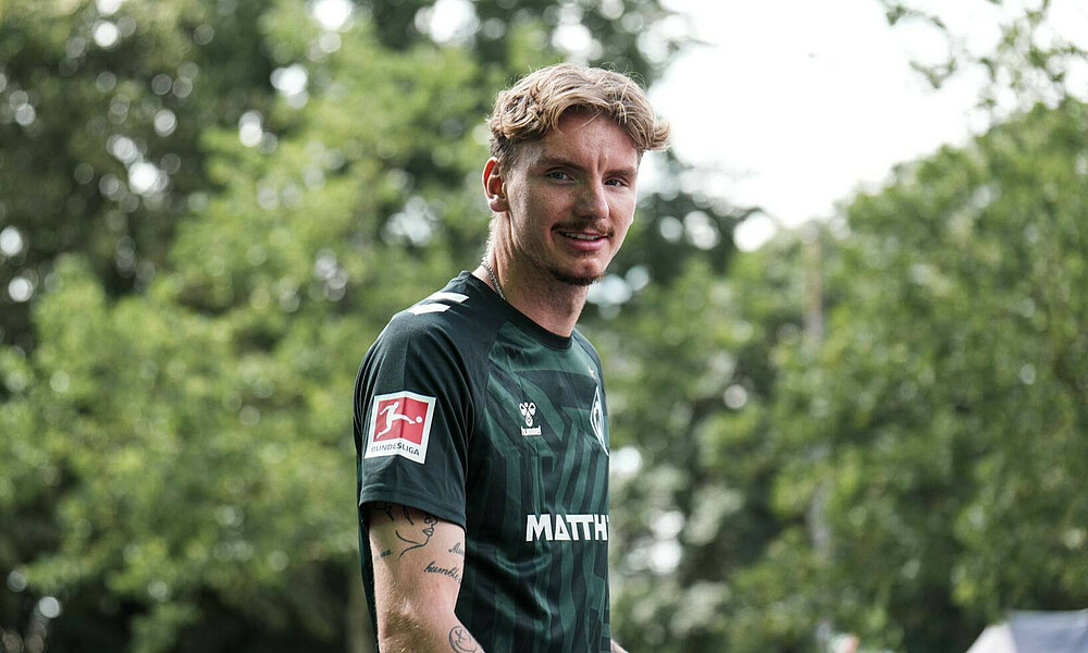 Nick Woltemade in the third kit, smiling at the camera.