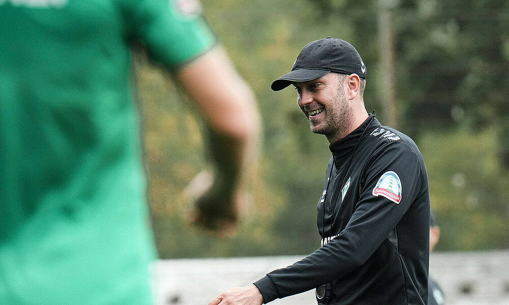 Ole Werner walks across the training pitch with a smile on his face.