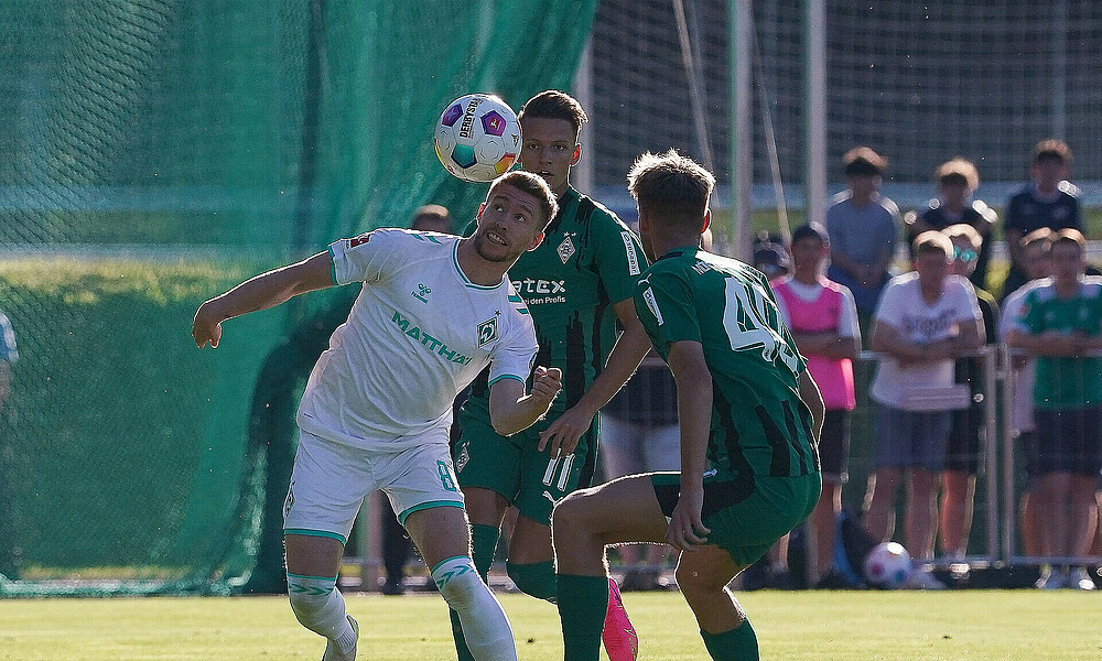 Mitchell Weiser heading a ball against a Gladbach player.