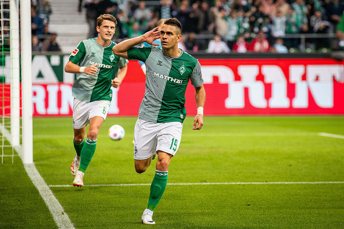 Rafael Borré running while cupping his right hand behind his right ear.