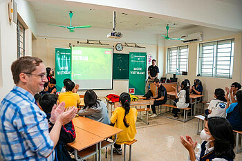 Representatives giving a presentation at the school (W.DE).