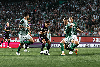 Musiala with the ball at his feet surrounded by Werder players.