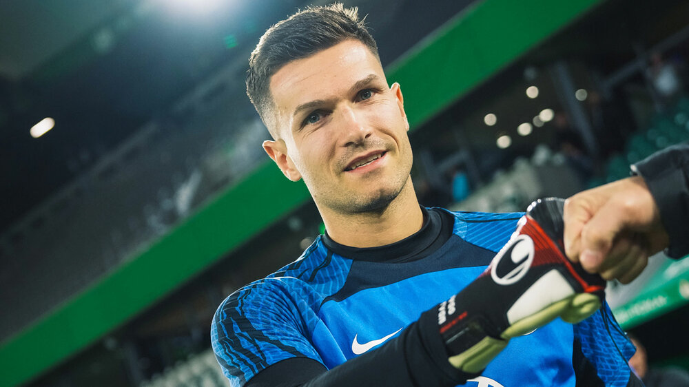 Pavao Pervan vor einem Spiel der VfL Wolfsburg in der Volkswagen Arena. Er lächelt.