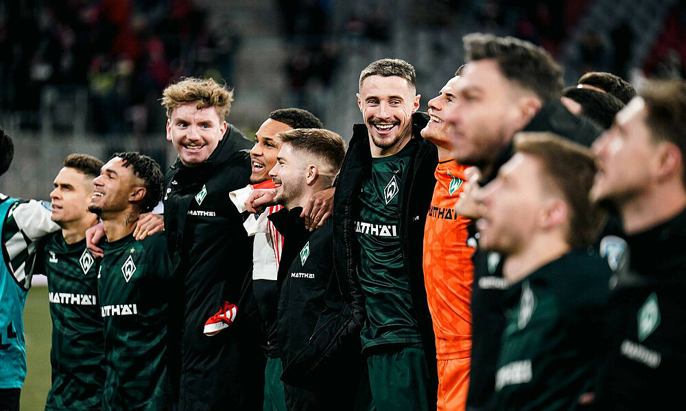 The team standing in front of the stands.