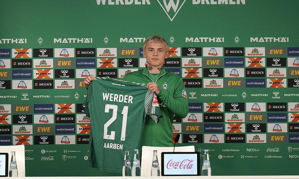 Hansen-Aarøen holds up his shirt.