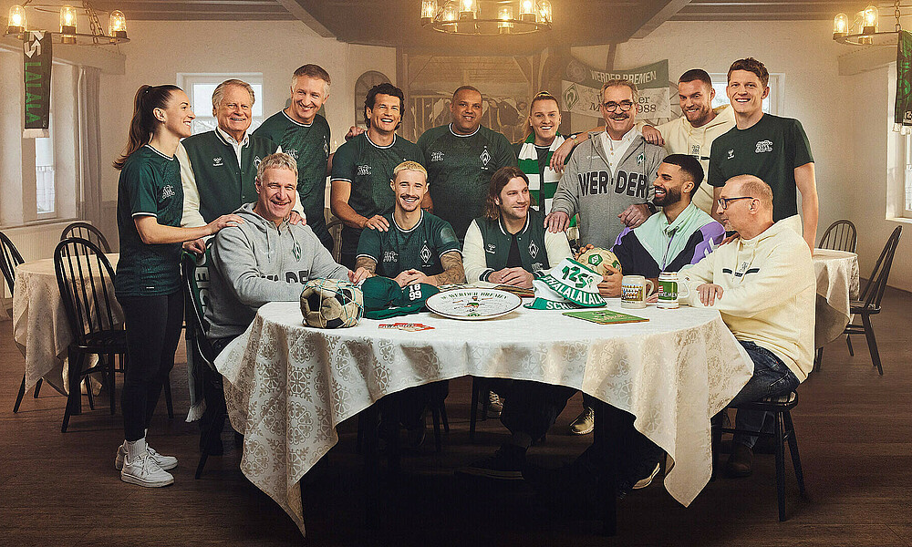 Werder players past and present sit around a table wearing the retro anniversary collection