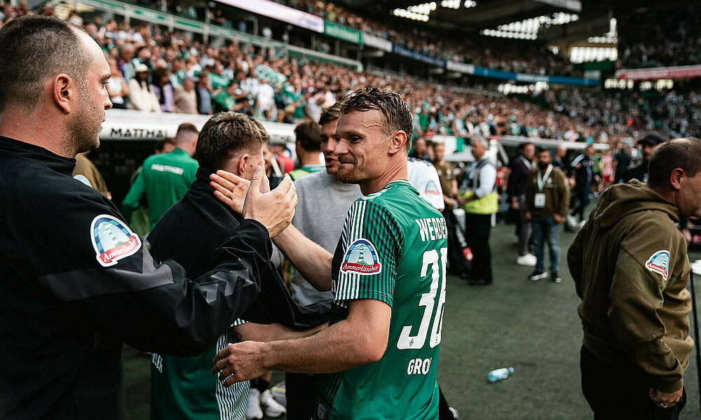 Christian Groß slaps hands with Ole Werner.