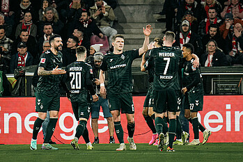 The Werder players celebrate the opening goal.