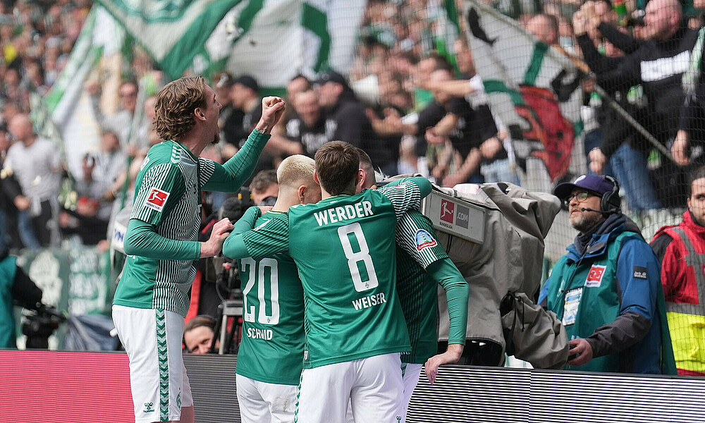 The team celebrating in front of the Ostkurve.