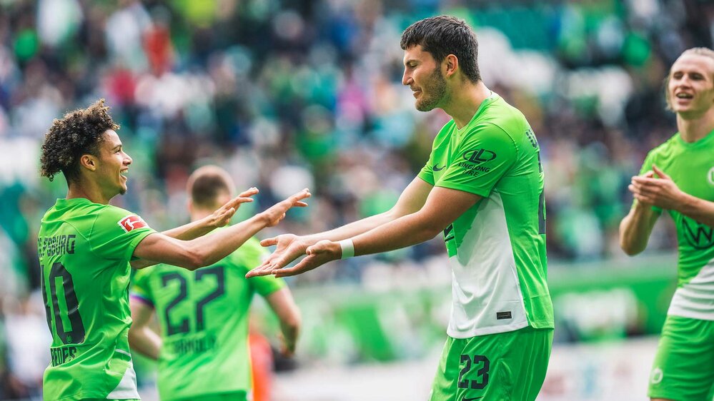 VfL-Wolfsburg-Spieler Jonas Wind jubelt gemeinsam mit Kevin Paredes.