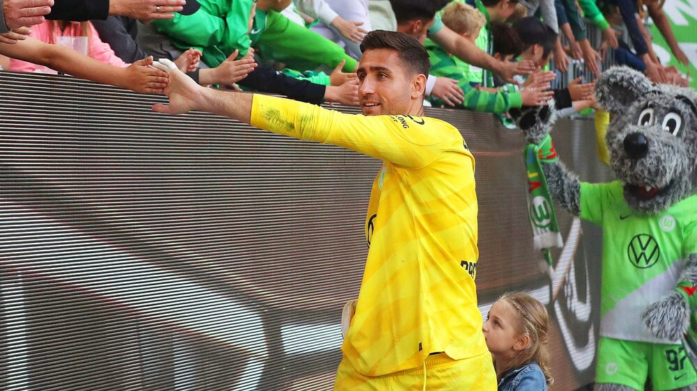 Der VfL-Wolfsburg-Spieler Koen Casteels klatscht mit einem Fan ab.