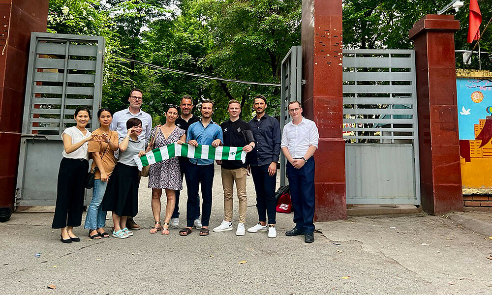 Delegation trip representatives standing in front of a sign.