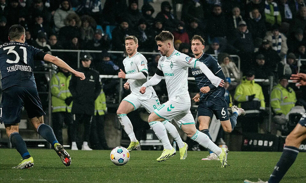 Romano Schmid dribbles against several opponents.