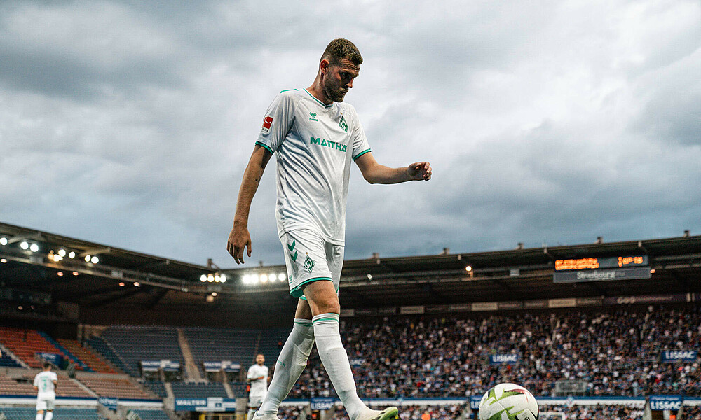 Marvin Ducksch in a white shirt standing by a corner flag with the ball.