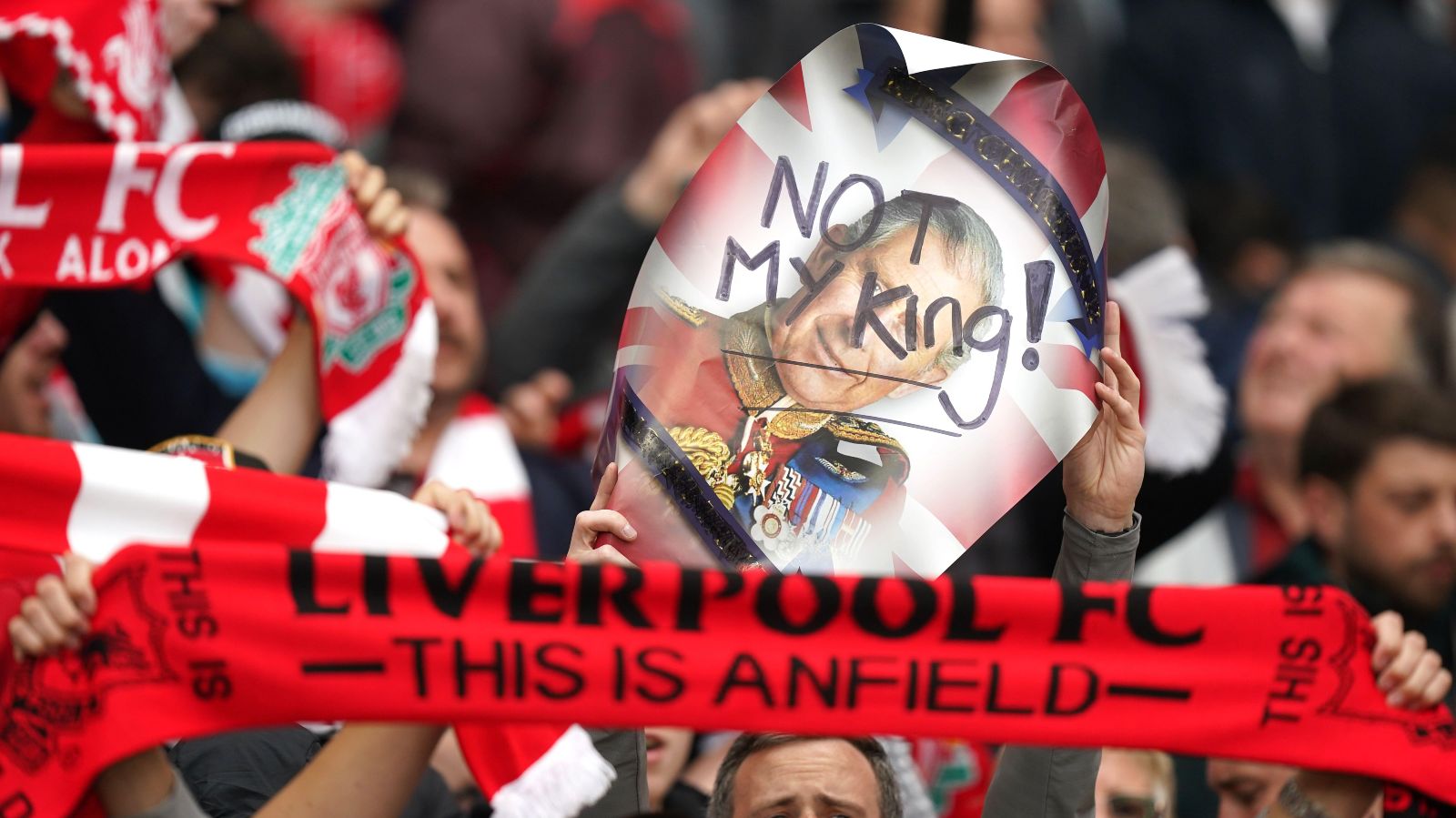 Liverpool fans hold banners in protest